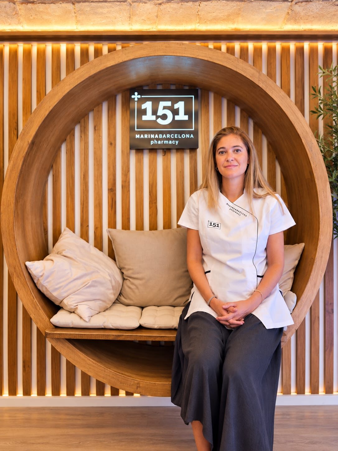 Begoña Barturen, farmacéutica titular, en el interior de la farmacia de Casp 151 junto al rótulo 151 Marina Barcelona pharmacy